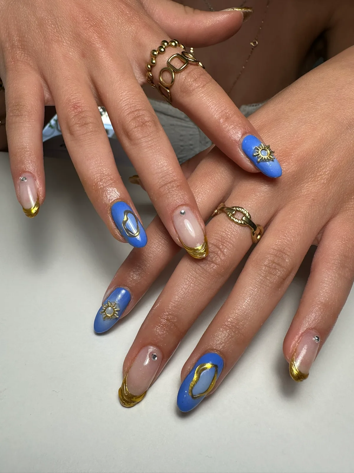 Unhas azuis com detalhes dourados